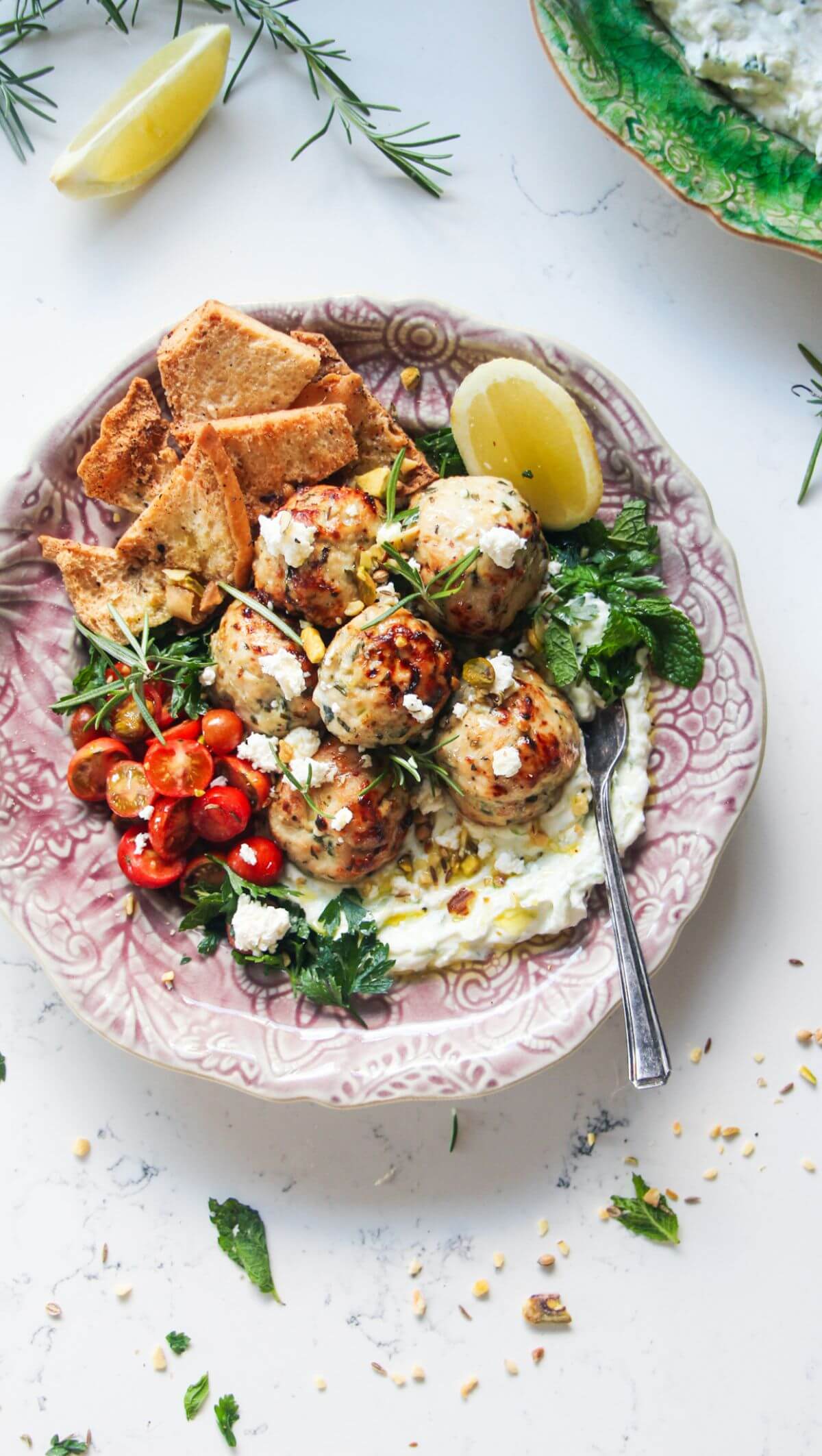 Fresh, zesty, juicy Greek chicken meatballs are a super easy, versatile 20 minute meal. Piled onto quick tzatziki sauce, topped with creamy feta, cherry tomatoes and herbs, they make a wonderful weeknight winner the whole family will love.
