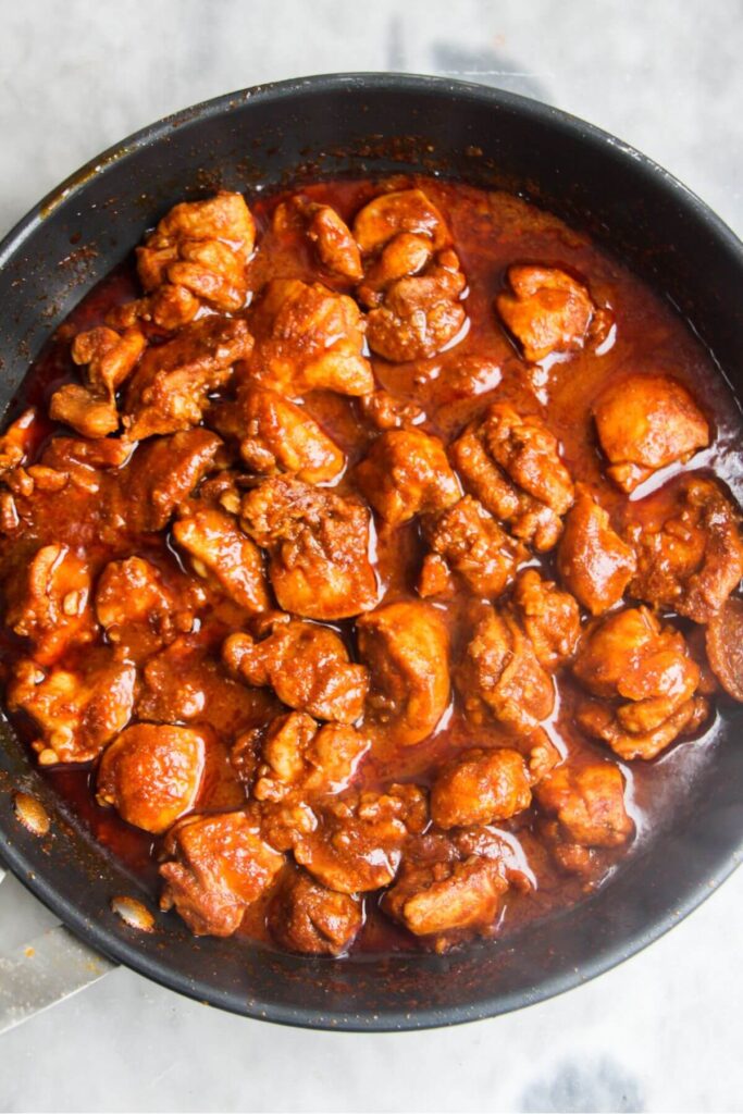 Chicken rogan josh thickening in a small frying pan.