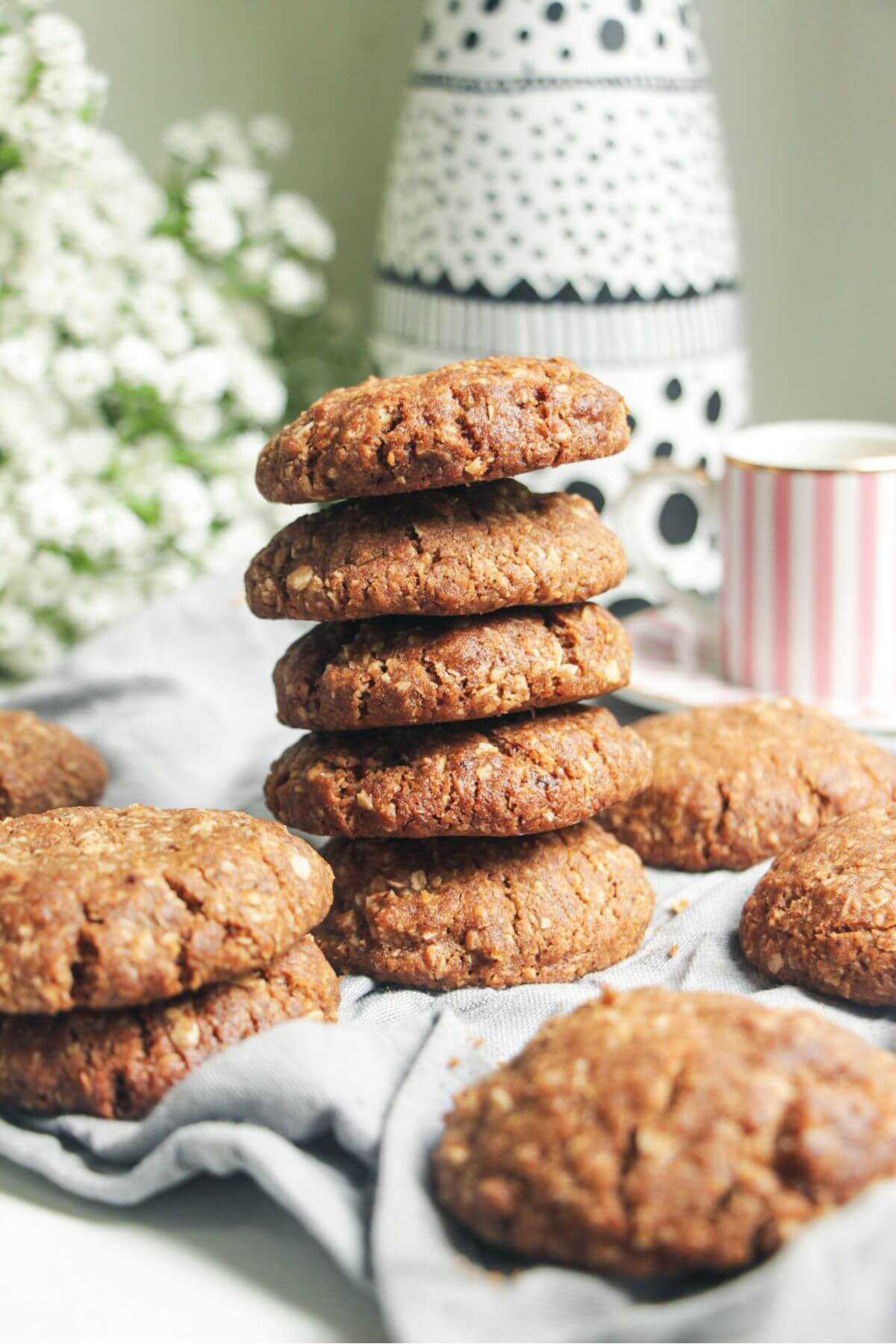 A stack of Anzac biscuits on a kitchen surface.