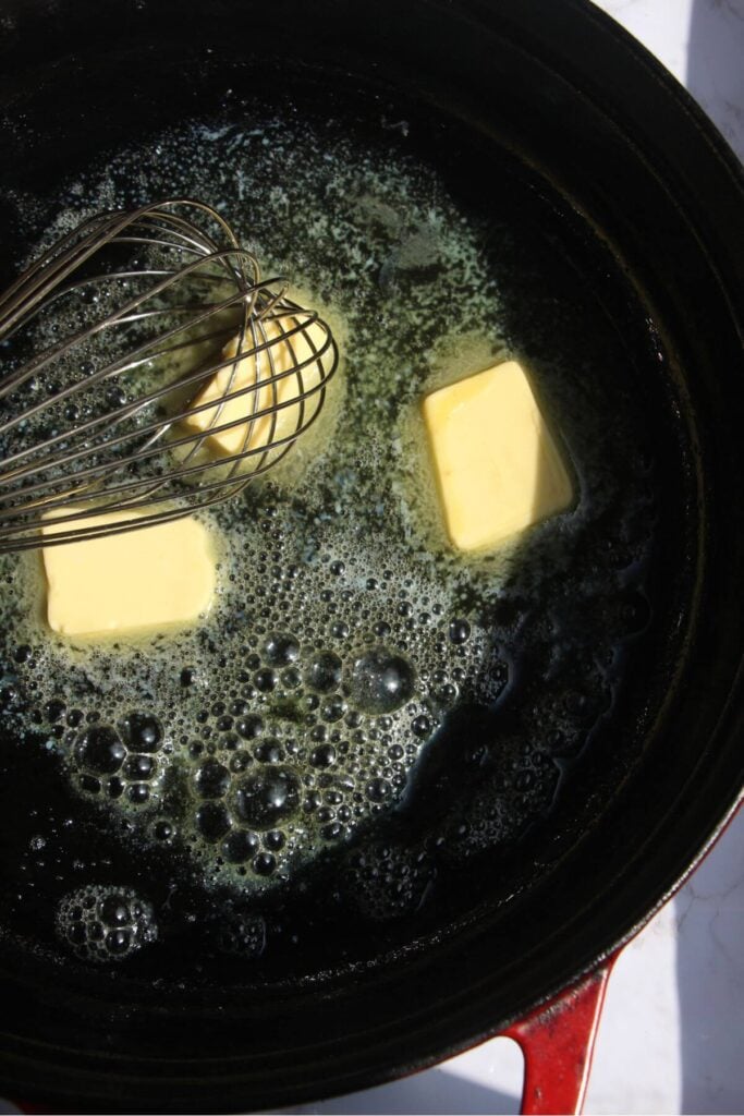 Butter melting in a large black pan.