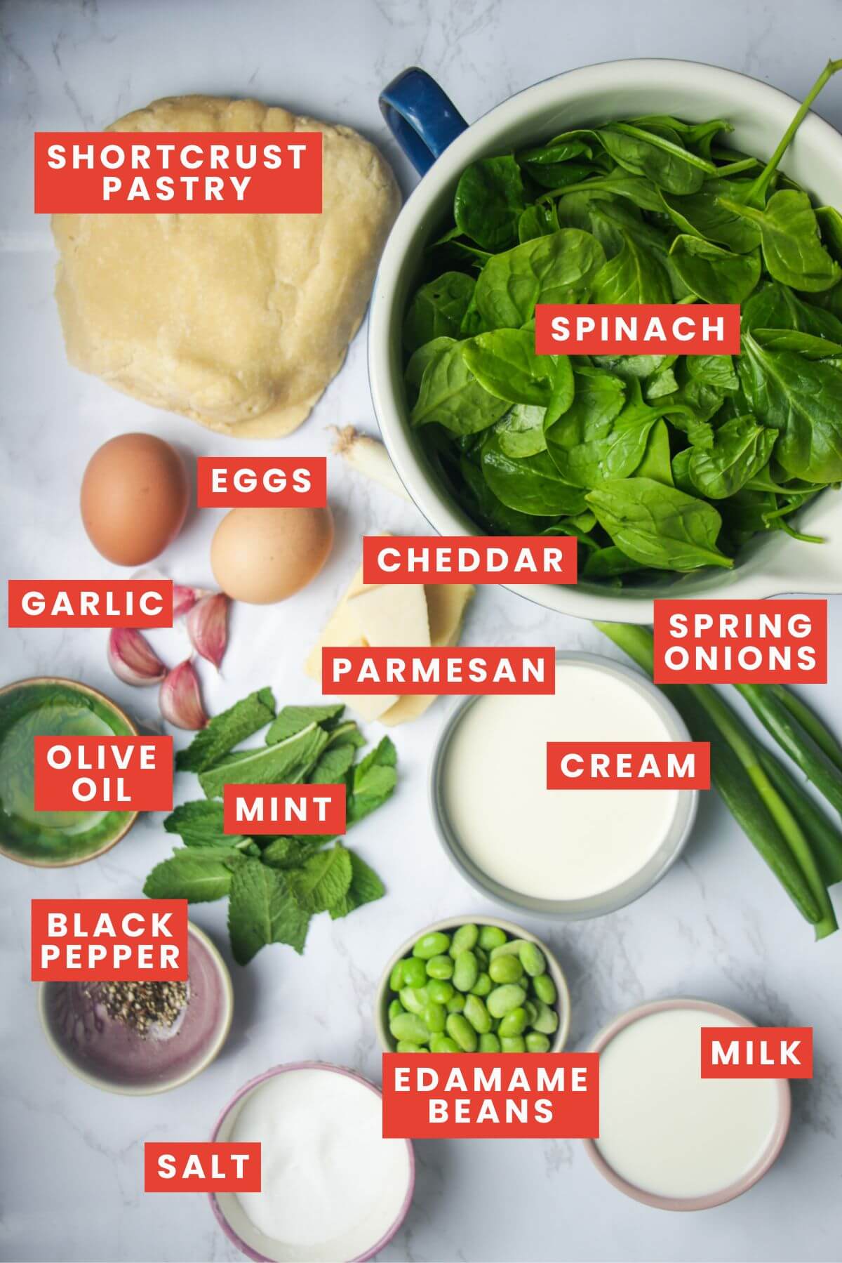 Ingredients for coronation quiche laid out on a white marble background.