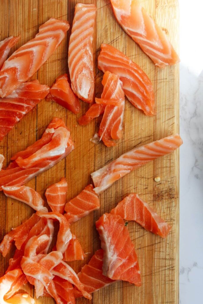 Thinly sliced salmon on a wooden board.