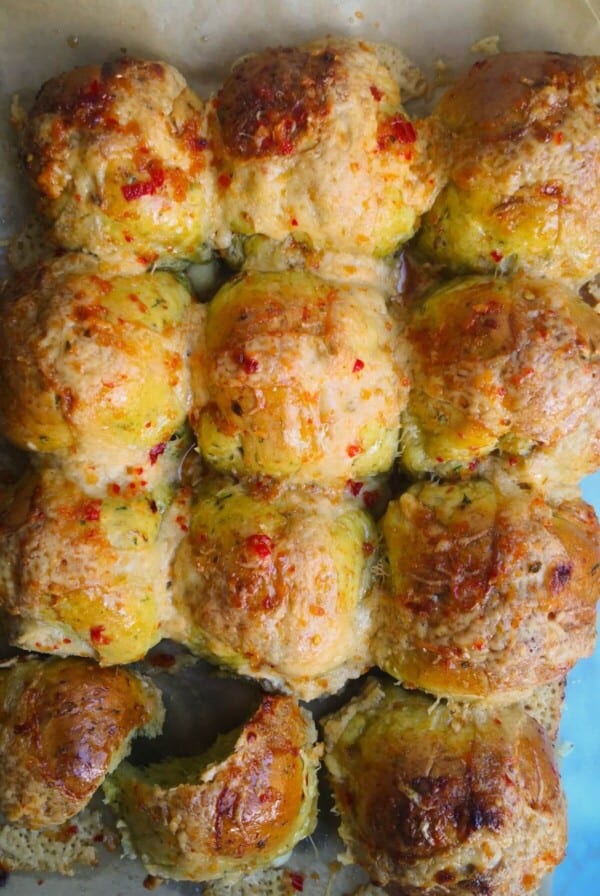12 wild garlic hot cross buns on a lined baking tray.