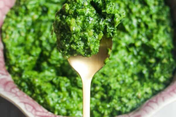 Close up of wild garlic pesto on a small gold spoon.