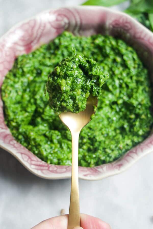 Close up of wild garlic pesto on a small gold spoon.