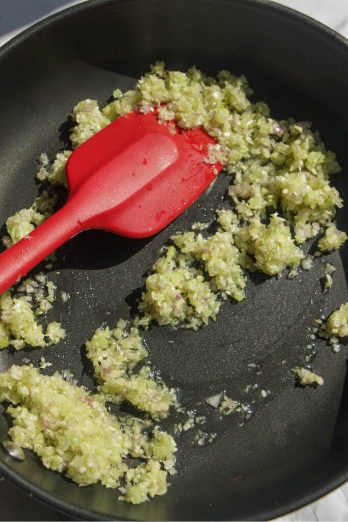 Stirring onion, garlic and celery in a small pan.