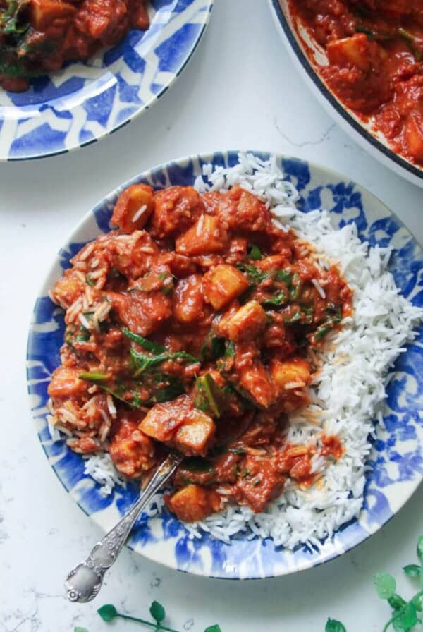 Creamy halloumi curry with spinach on rice on a small plate.