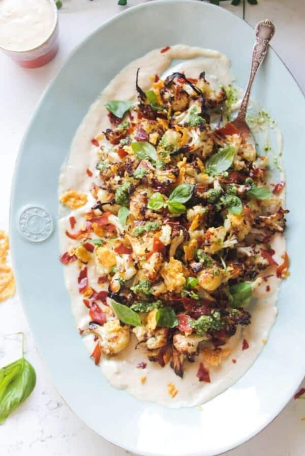 Parmesan roasted cauliflower salad on an oven blue plate with crispy parmesan and prosciutto.