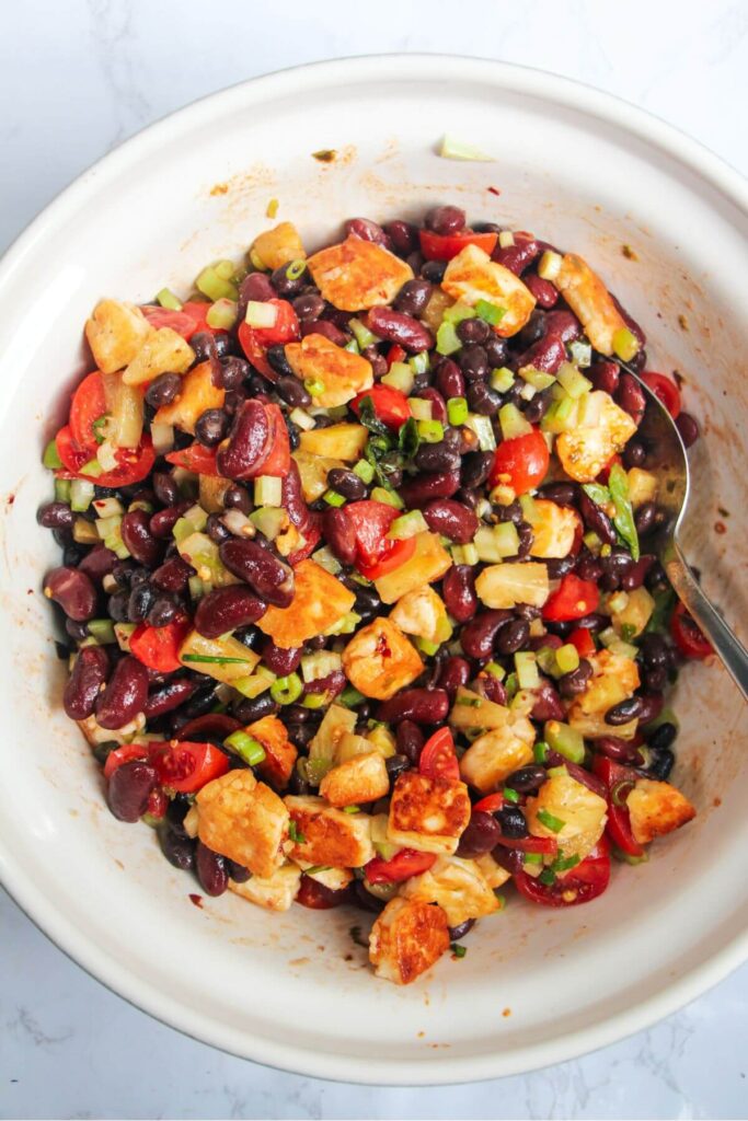 Mexican bean salad mixed in a large white mixing bowl.