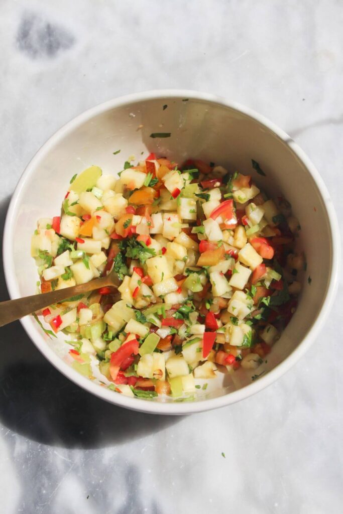 Pineapple salsa mixed in a small white bowl.