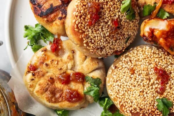 Close up of a pile of pizza pocket, with one torn open showing the cheesy gochujang centre.