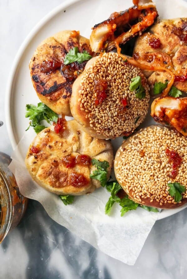 Close up of a pile of pizza pocket, with one torn open showing the cheesy gochujang centre.
