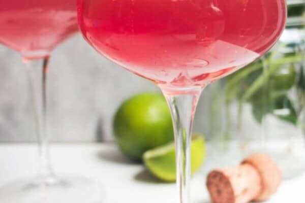 Pink Barbie spritz in a glass coupe, with another glass in the background.