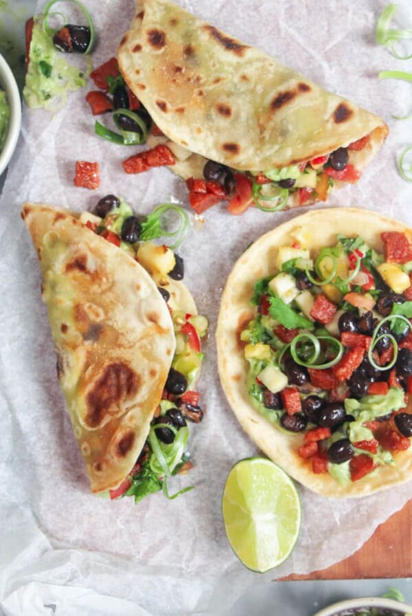 Three chorizo and black bean tacos on a grey marble background.