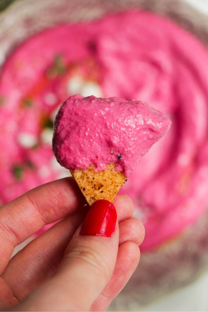 Close up of beetroot dip on a pita chip.