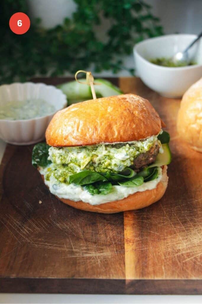 Juicy lamb burger assembled on a wooden board.