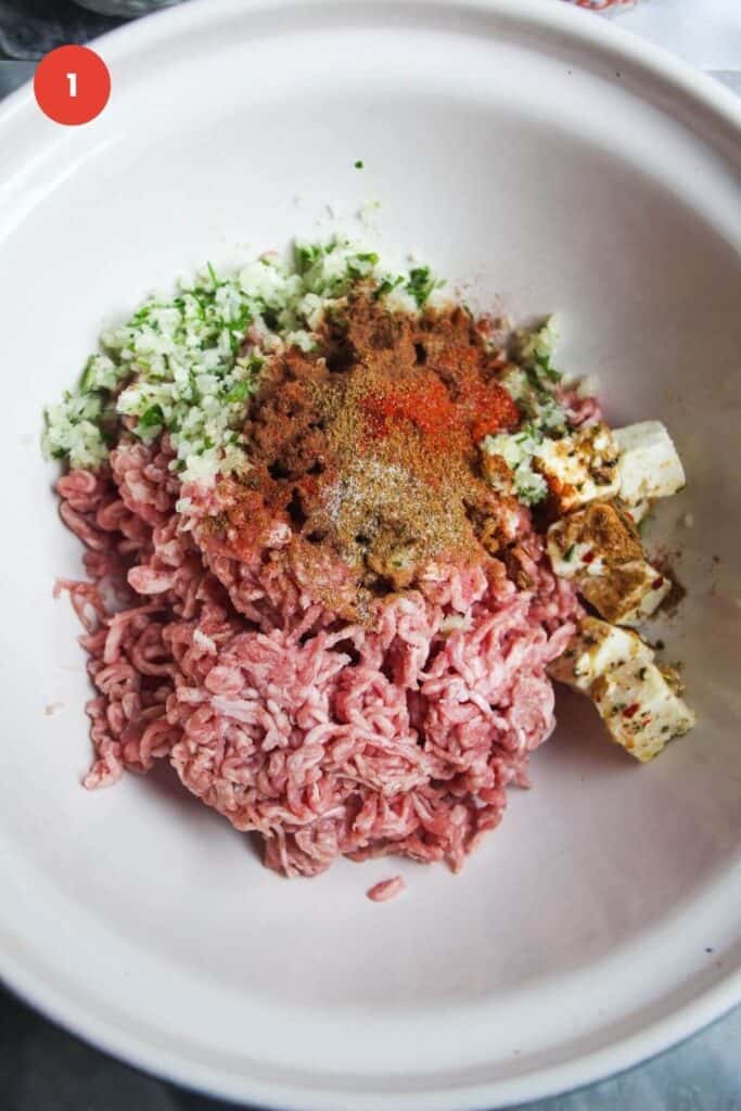 Ground lamb with spices in a large mixing bowl.