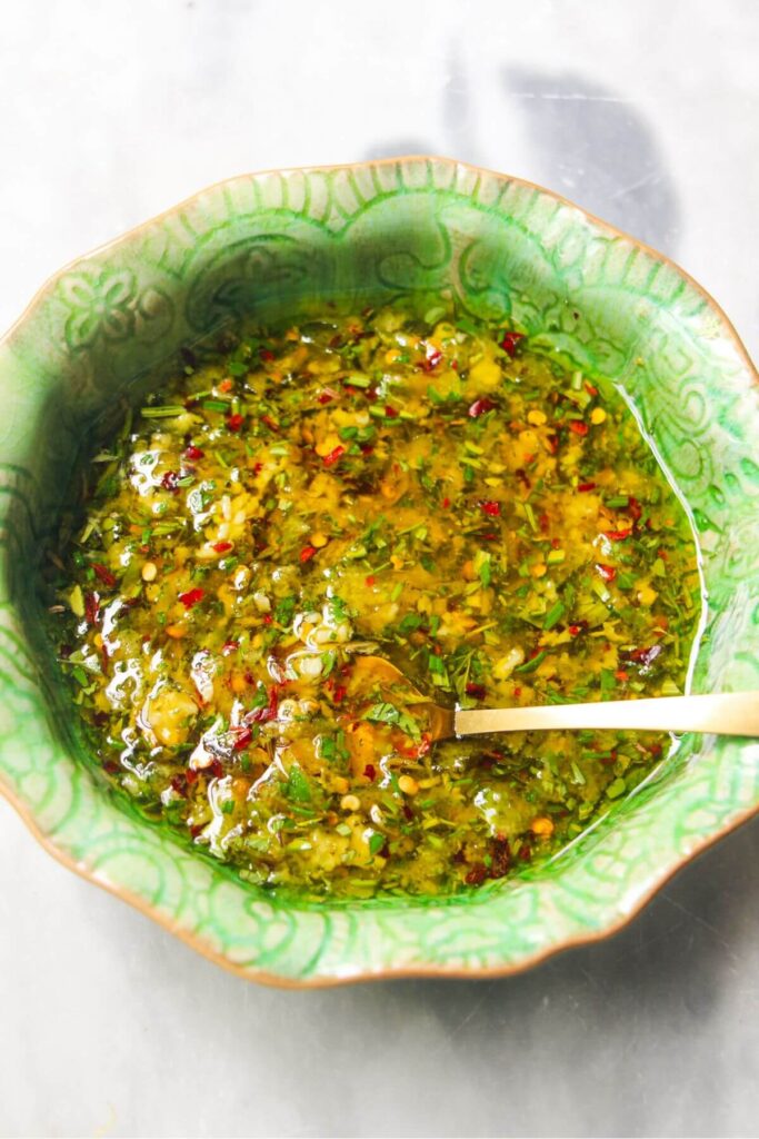 Olive marinade mixed in a small green bowl.