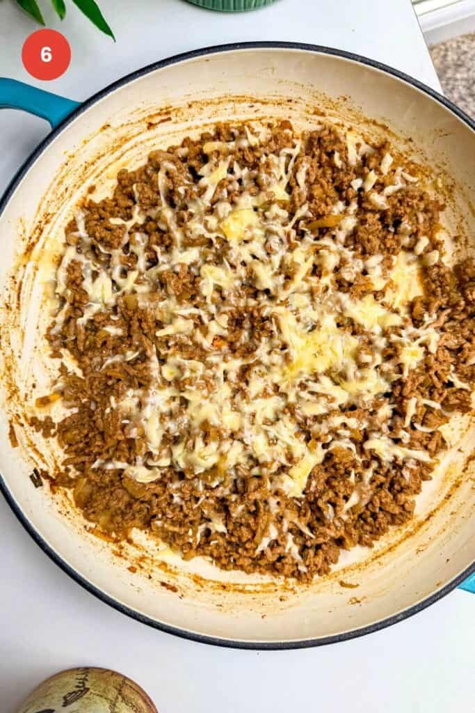 Cheese melted over cheeseburger beef in a pan.