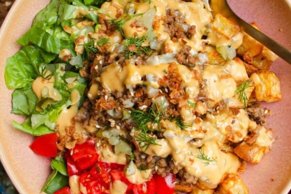 Holding loaded cheeseburger bowls drizzled with burger sauce.