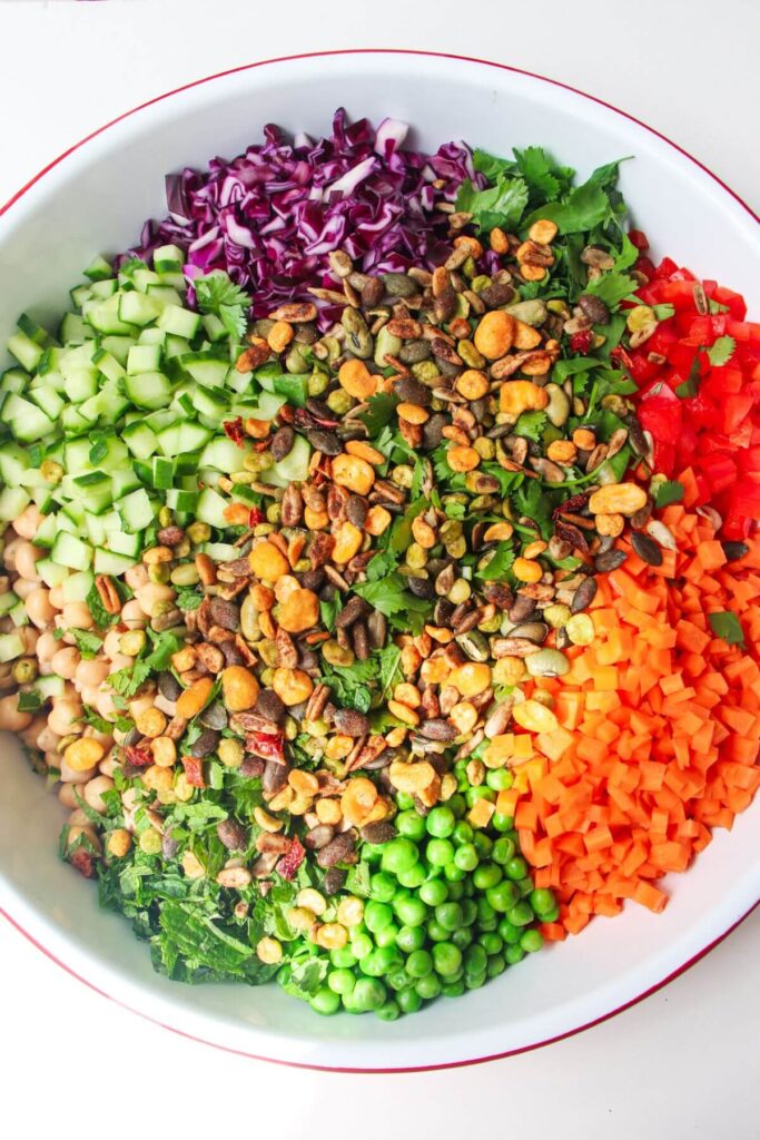 Rainbow chopped salad ingredients in a large white bowl.