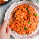 Creamy tomato sausage gnocchi served in a decorative bowl with basil garnish.
