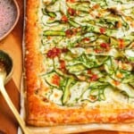 Zucchini and boursin tart on wooden board.