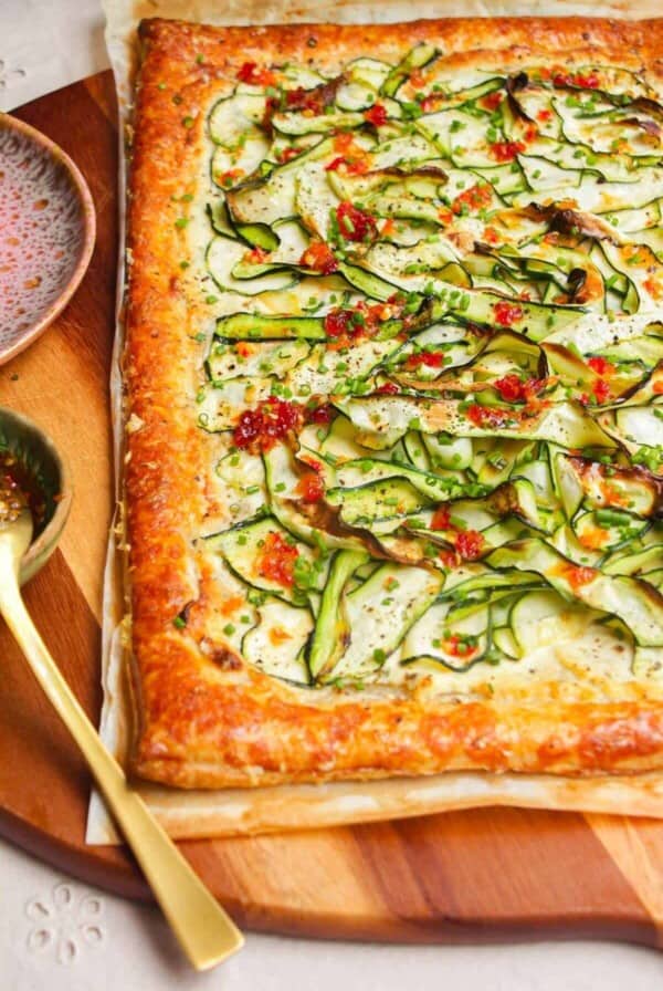 Zucchini and boursin tart on wooden board.