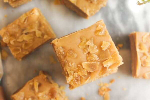 Pile of ginger crunch on top of each other with a coffee cup on the side.