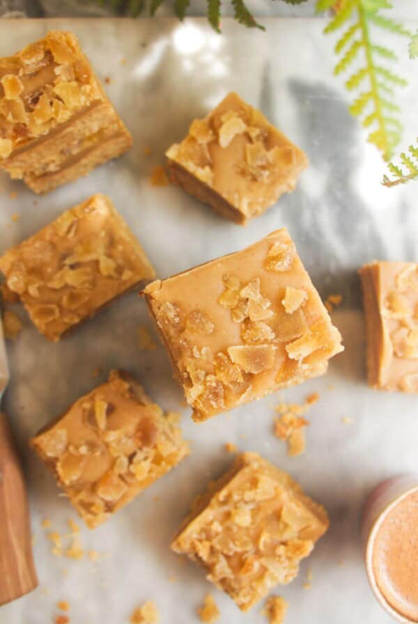 Pile of ginger crunch on top of each other with a coffee cup on the side.