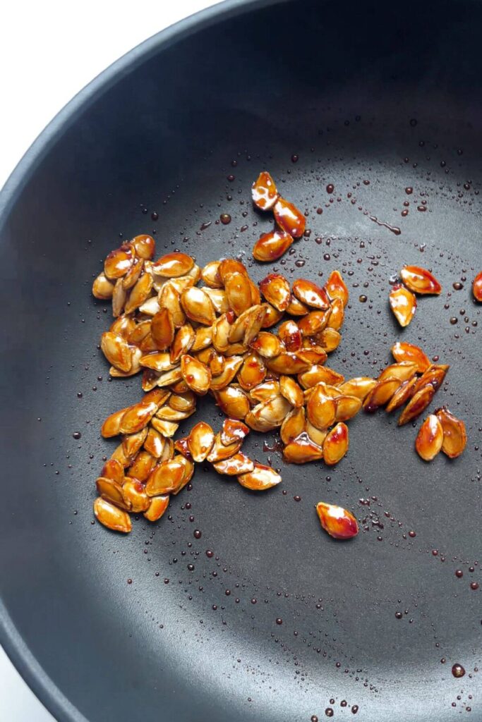 Salted honey squash seeds in a small pan.