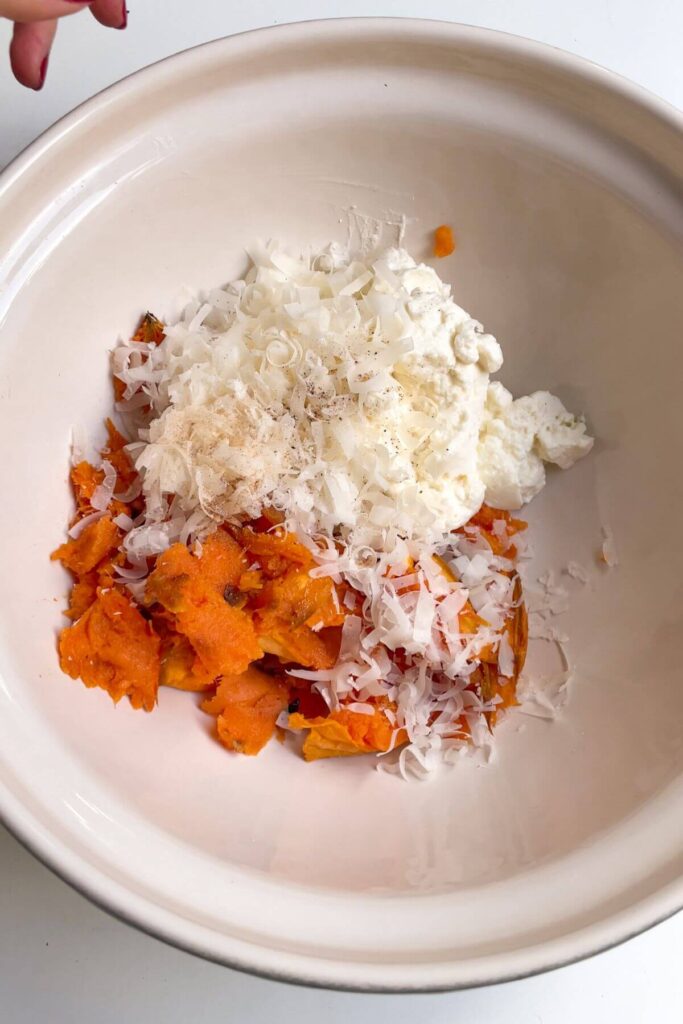 Sweet potato, ricotta, parmesan in a large mixing bowl.