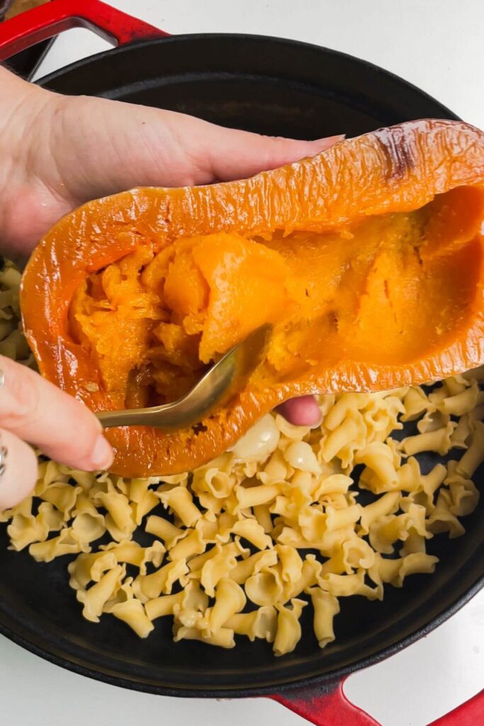 Scooping roasted butternut squash out of its skin.