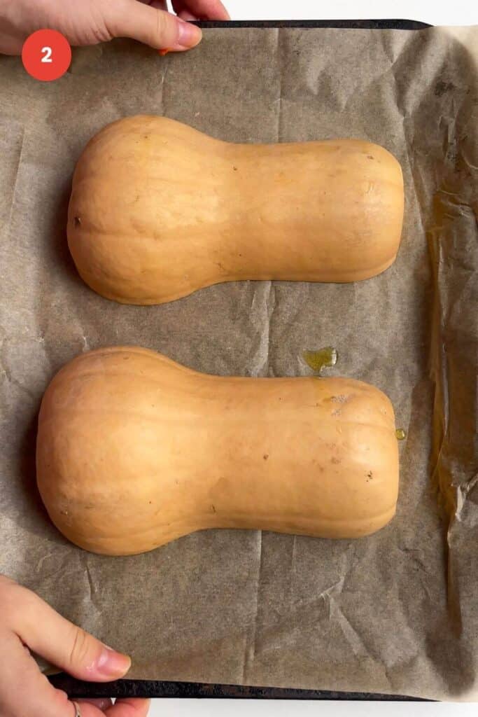 Butternut squash halves set on lined oven tray.