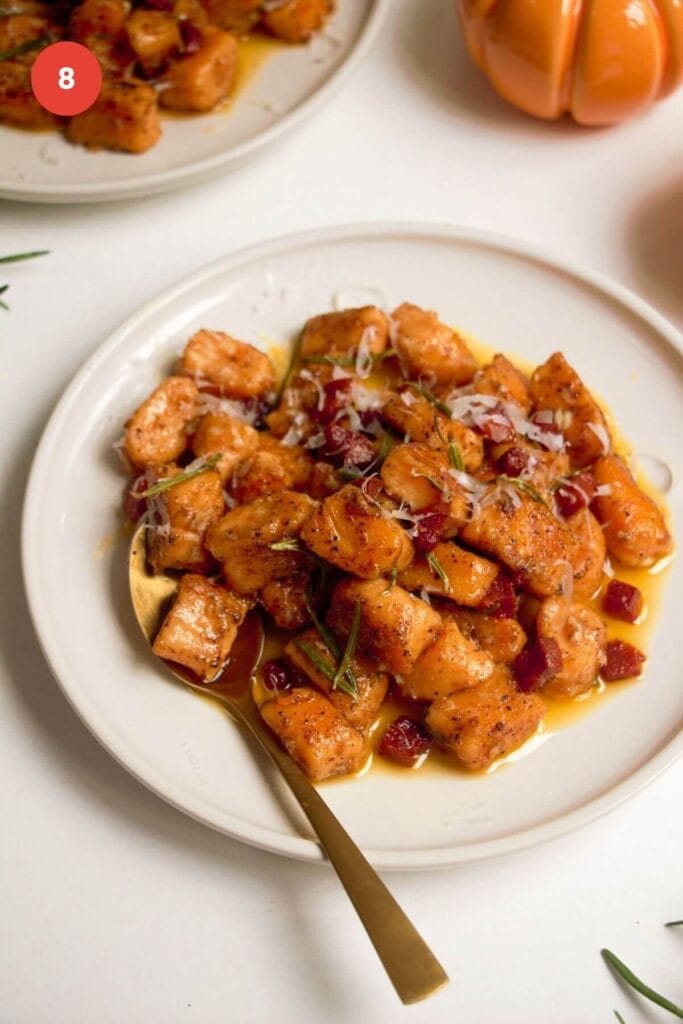 Sweet potato gnocchi served on a plate in brown butter sauce with chorizo.