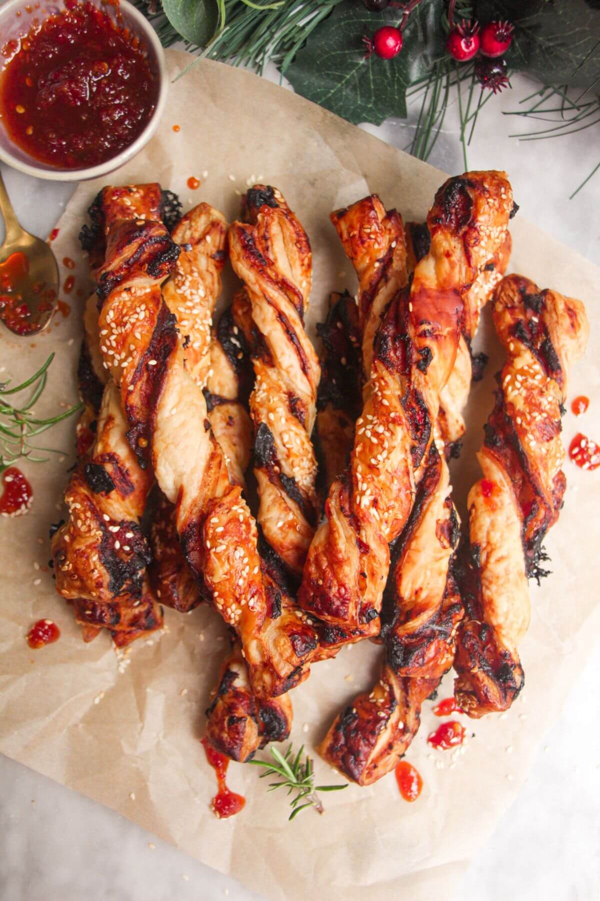 A pile of bacon, blue cheese and sweet chilli twists on a sheet of baking paper.