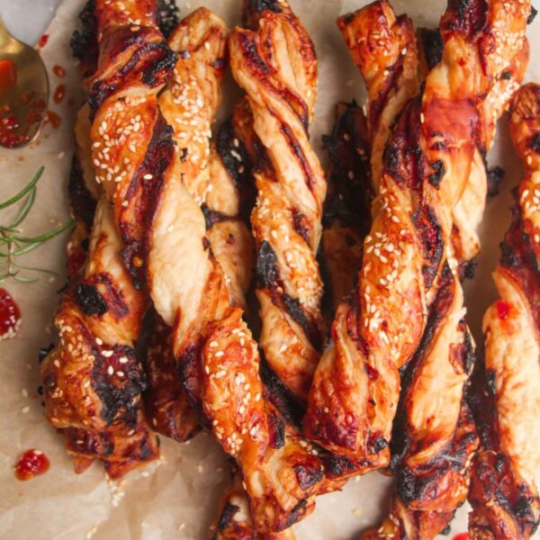 A pile of bacon, blue cheese and sweet chilli twists on a sheet of baking paper.