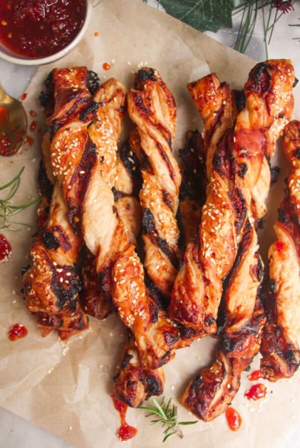 A pile of bacon, blue cheese and sweet chilli twists on a sheet of baking paper.