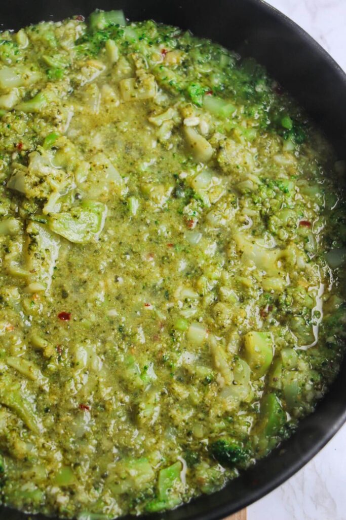 Broccoli broken down in a pan with garlic and anchovies.