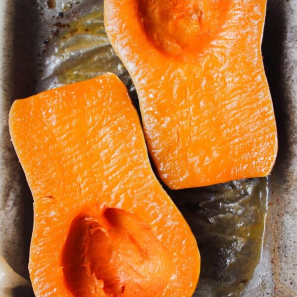 Soft roasted squash on a lined oven tray.