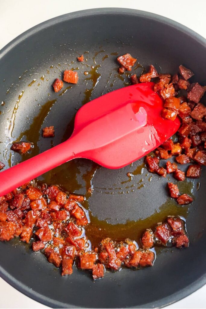 Chorizo cooking in a small pan.