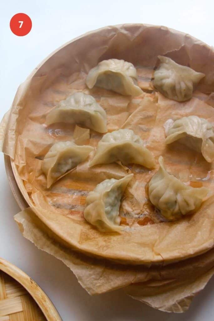 Dumplings steamed in a steamer basket.