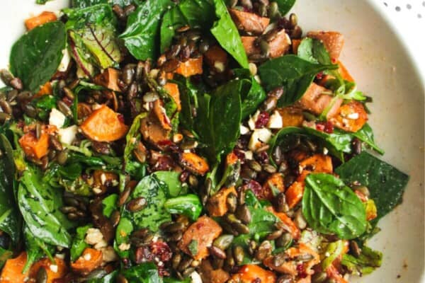 Roasted sweet potato salad in a large white and blue bowl.