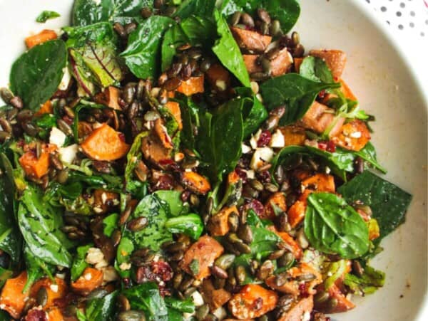 Roasted sweet potato salad in a large white and blue bowl.