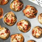 Close up of baked sundried tomato feta cups in a mini muffin tin.