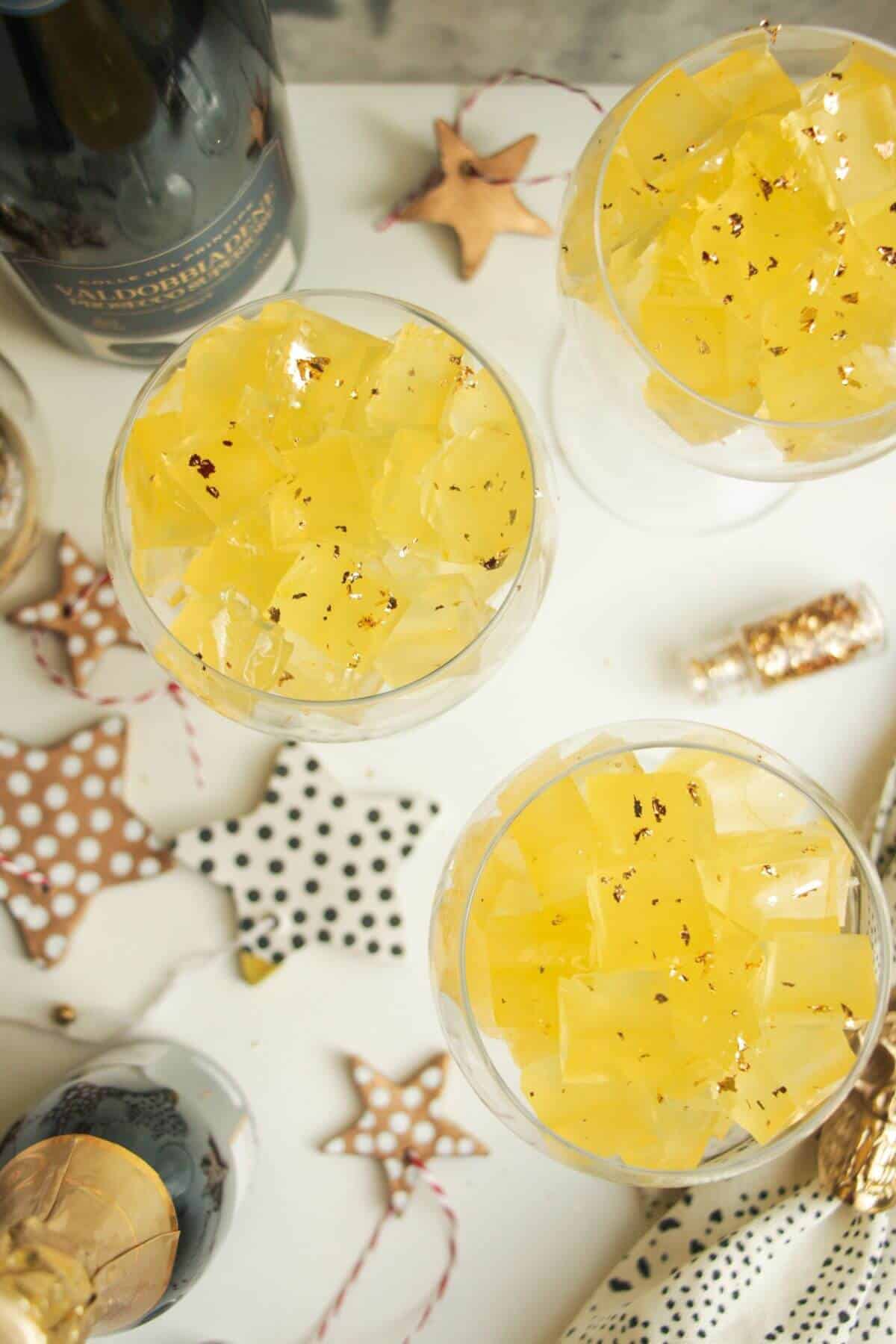 Birds eye view of three champagne coupes filled with jello cubes.