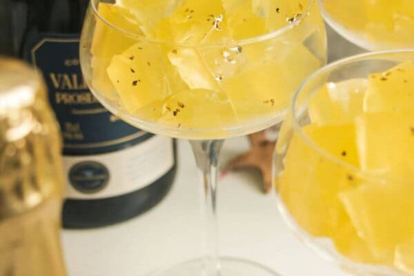 Three champagne coupes filled with jello cubes.