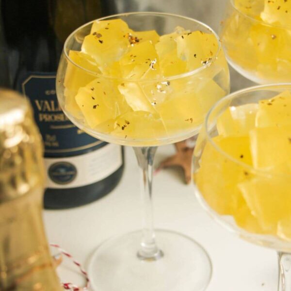 Three champagne coupes filled with jello cubes.