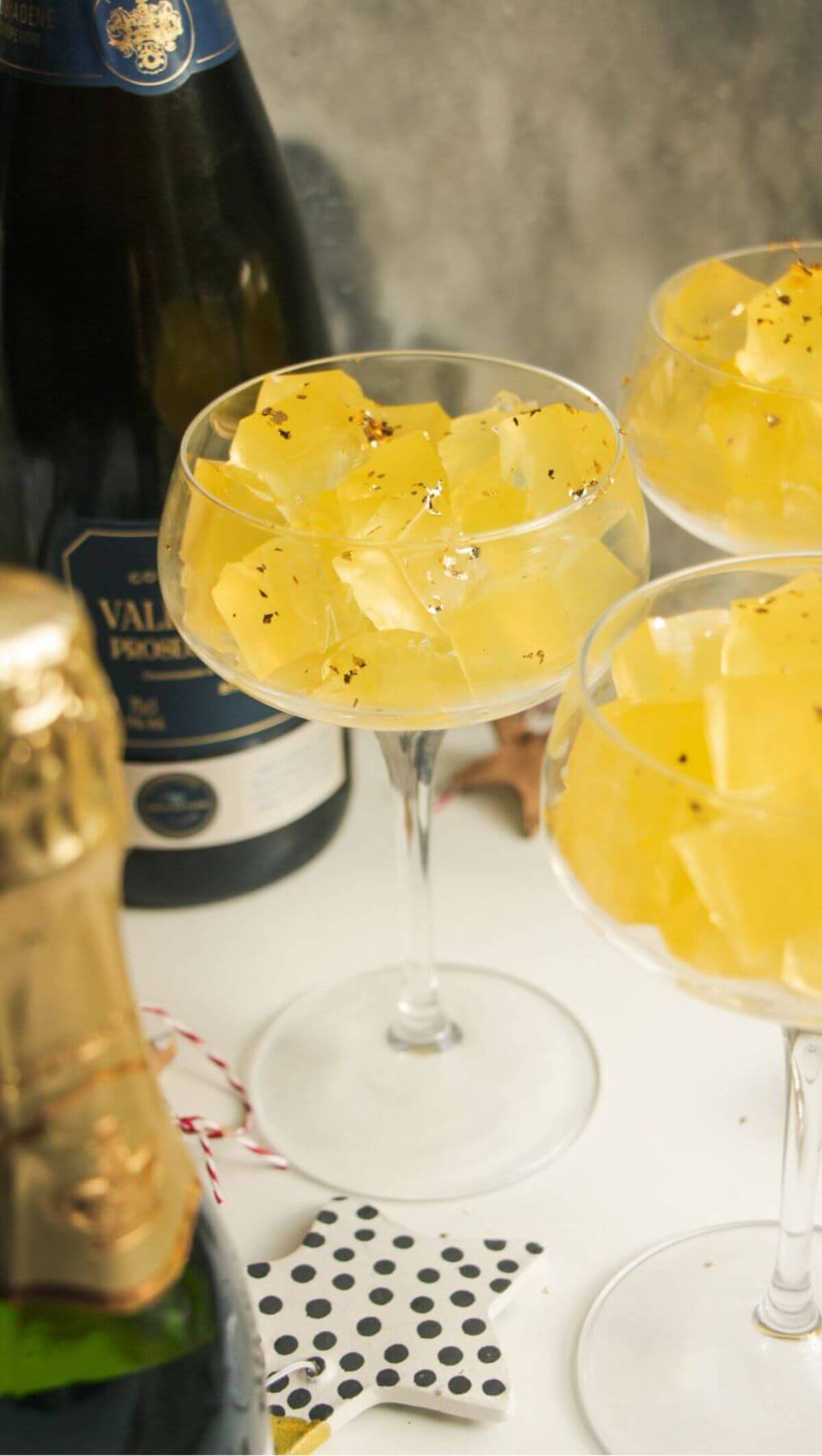 Three champagne coupes filled with jello cubes.