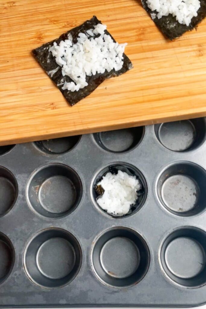 One rice filled nori square pressed into a mini muffin tin.